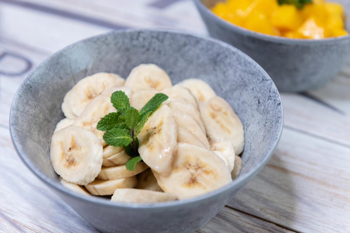 fresh banana slices in grey bowl with mint