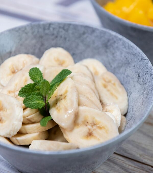 fresh banana slices in grey bowl with mint
