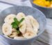 fresh banana slices in grey bowl with mint